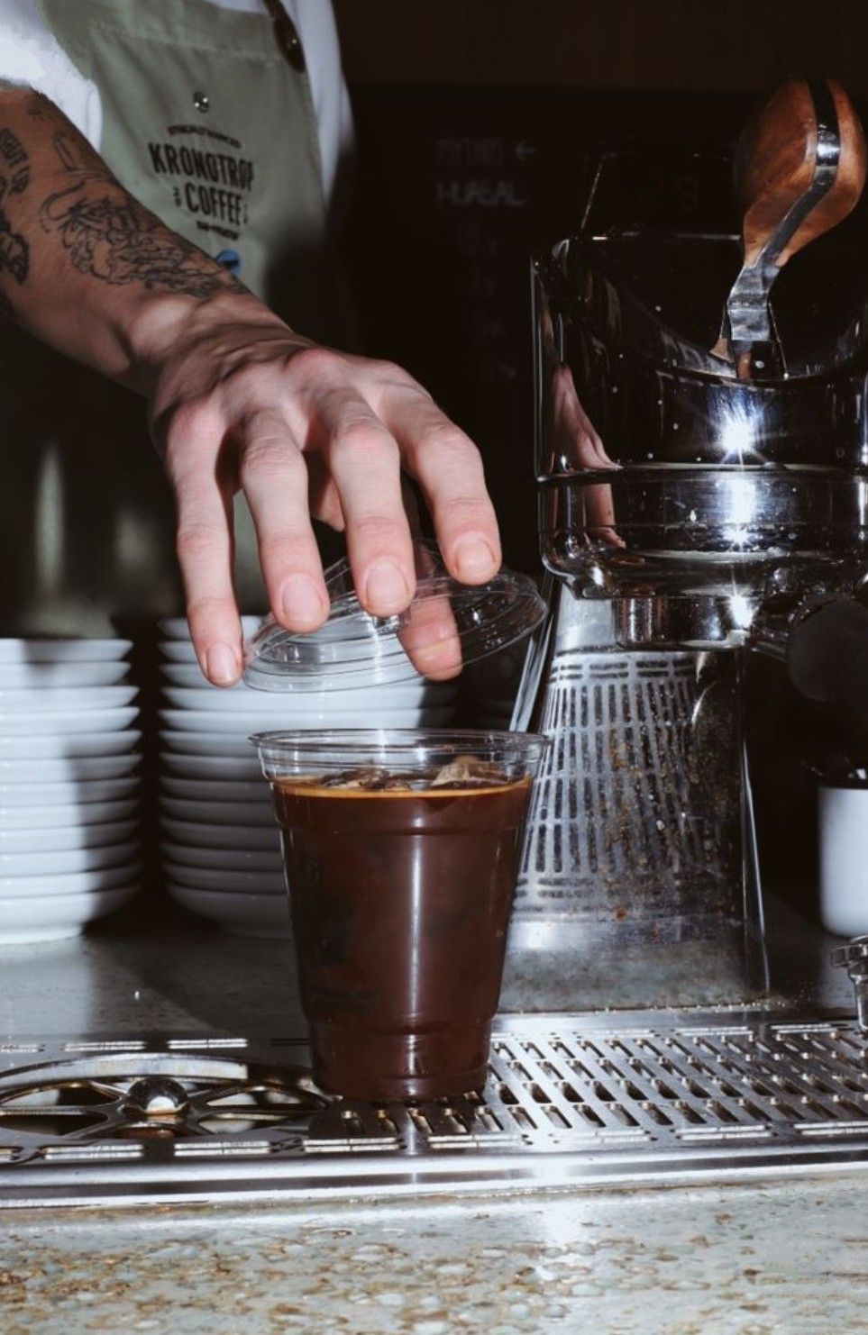 Barista placing a lid on an iced coffee at the counter
