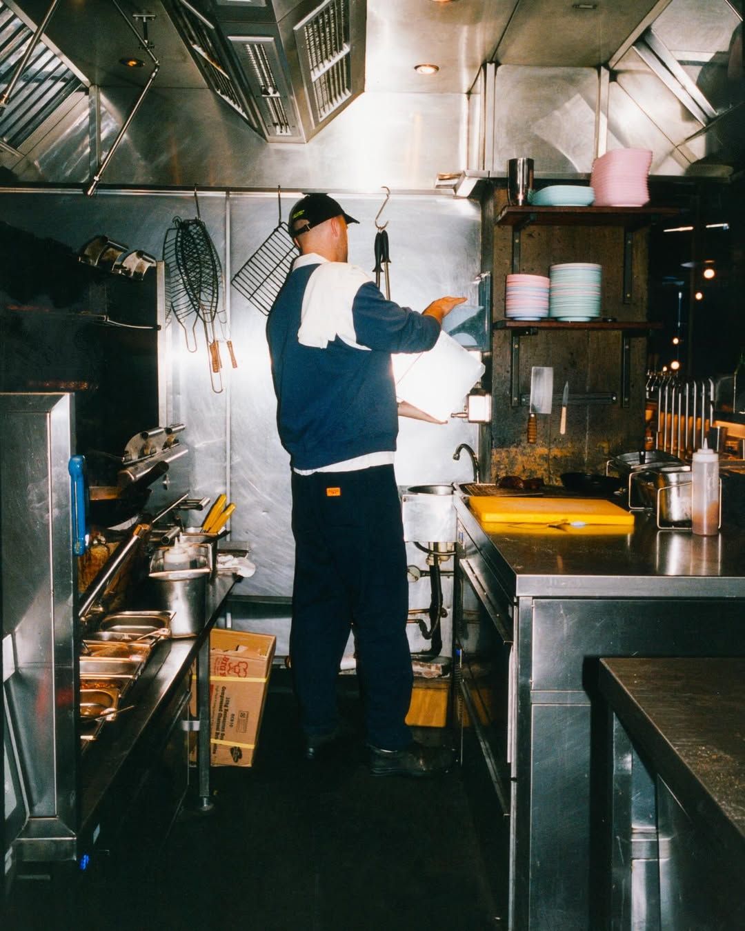 Cook working the line in a stainless steel kitchen