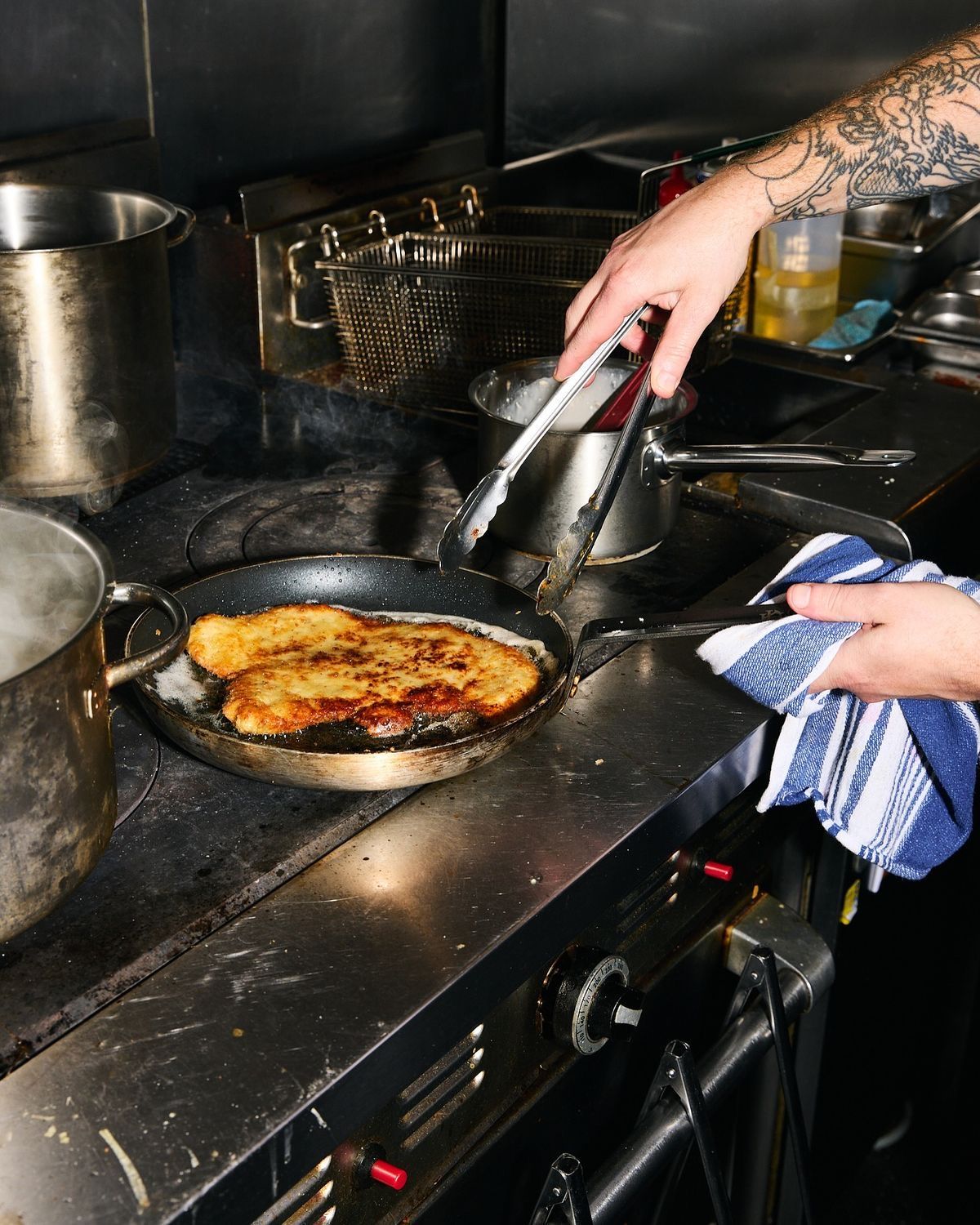 Chef working a pan on the stove during service